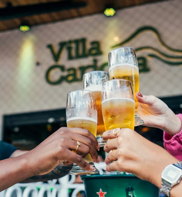 Brinde com chopp Brahma em frente ao letreiro do Villa Carioca